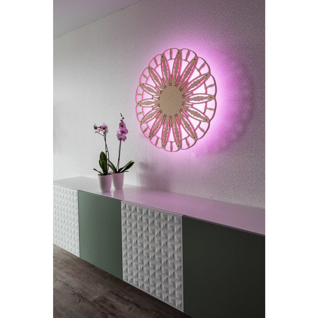 KuvaLight Anemone wall lamp, bamboo finish, ⌀ 80 cm, with pink light above orchids in an office.