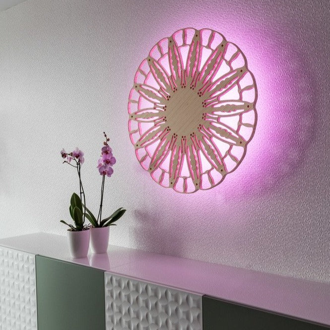 KuvaLight Anemone wall lamp, bamboo finish, ⌀ 80 cm, with pink light above orchids in an office.