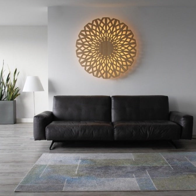 KuvaLight Amsterdam in Bamboo with a yellow light during the day. The 115cm big KuvaLight hangs above a dark brown leather sofa.