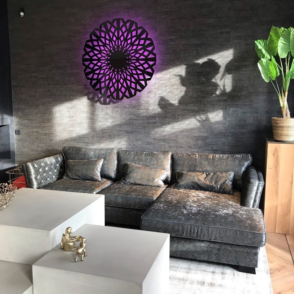 KuvaLight Amsterdam in Piano Black with the light in a pink/purple color against a dark grey wall in a home setting.