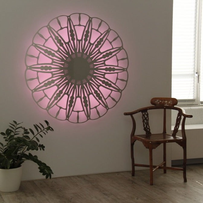 KuvaLight Anemone wall lamp in brushed aluminum with pink light, featured in a cozy home interior.