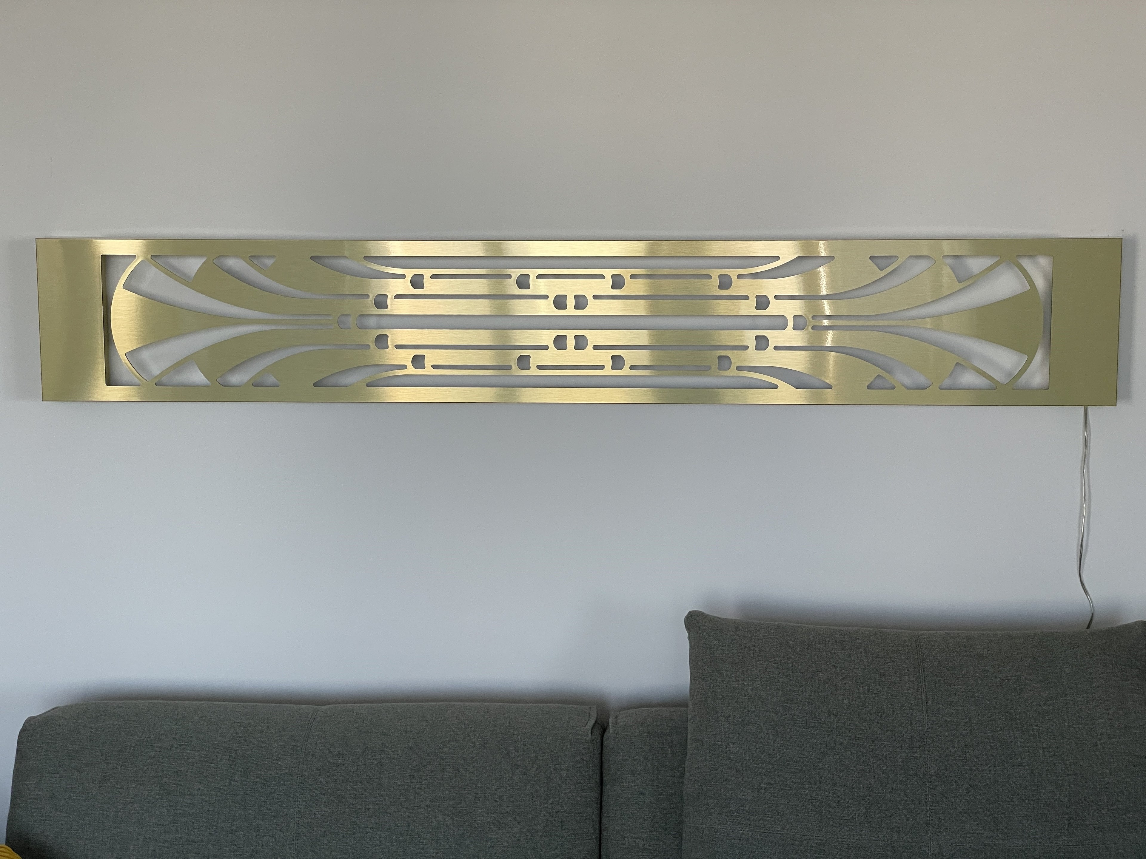 KuvaLight Art Deco Miami Slim wall light in horizontal position above couch with light turned off, showcasing linear design.