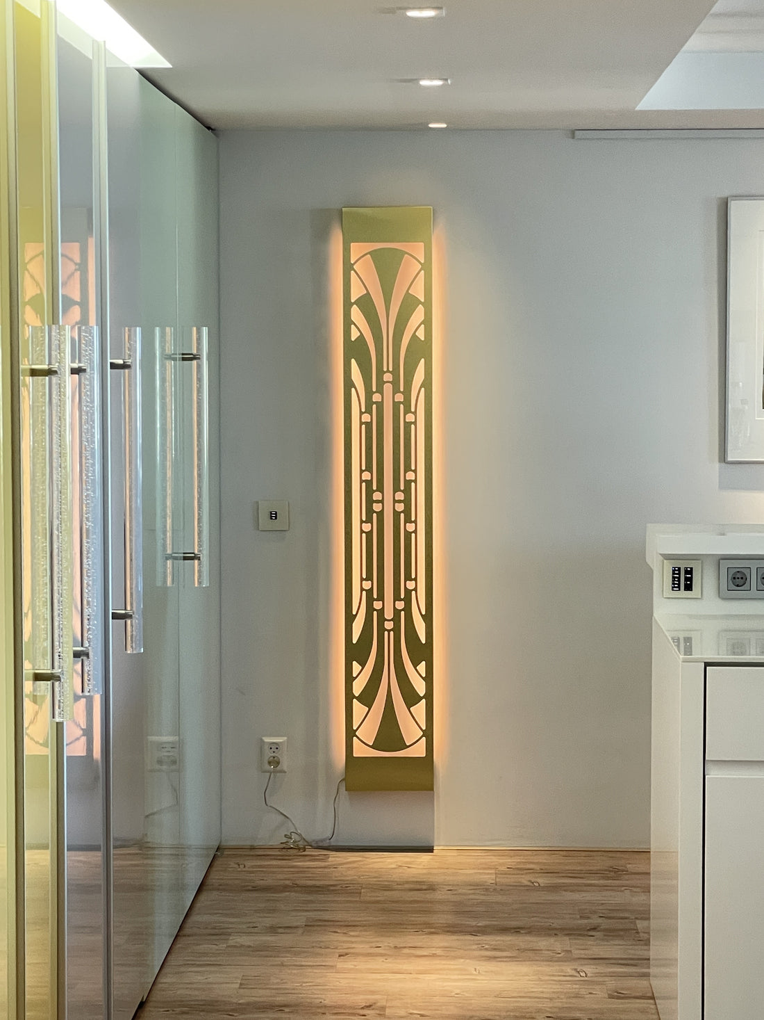 KuvaLight Art Deco Miami Slim wall light in brushed finish, vertically mounted at the end of a hallway with warm light on.