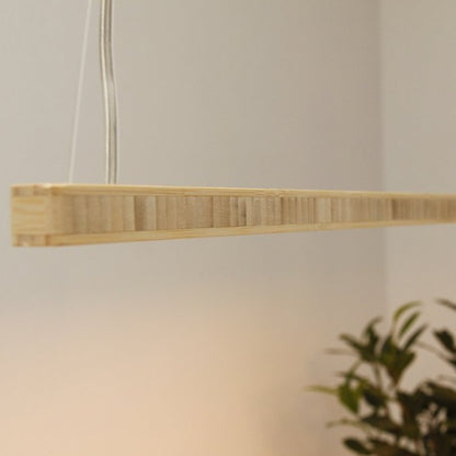 Close up from the KuvaLight Line in Bamboo hanging above a desk. The color of the light can be adjusted from warm white to energizing cool white light and is also dimmable.