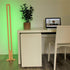 KuvaLight Parallel in Bamboo with a green relaxing light standing next to a desk.