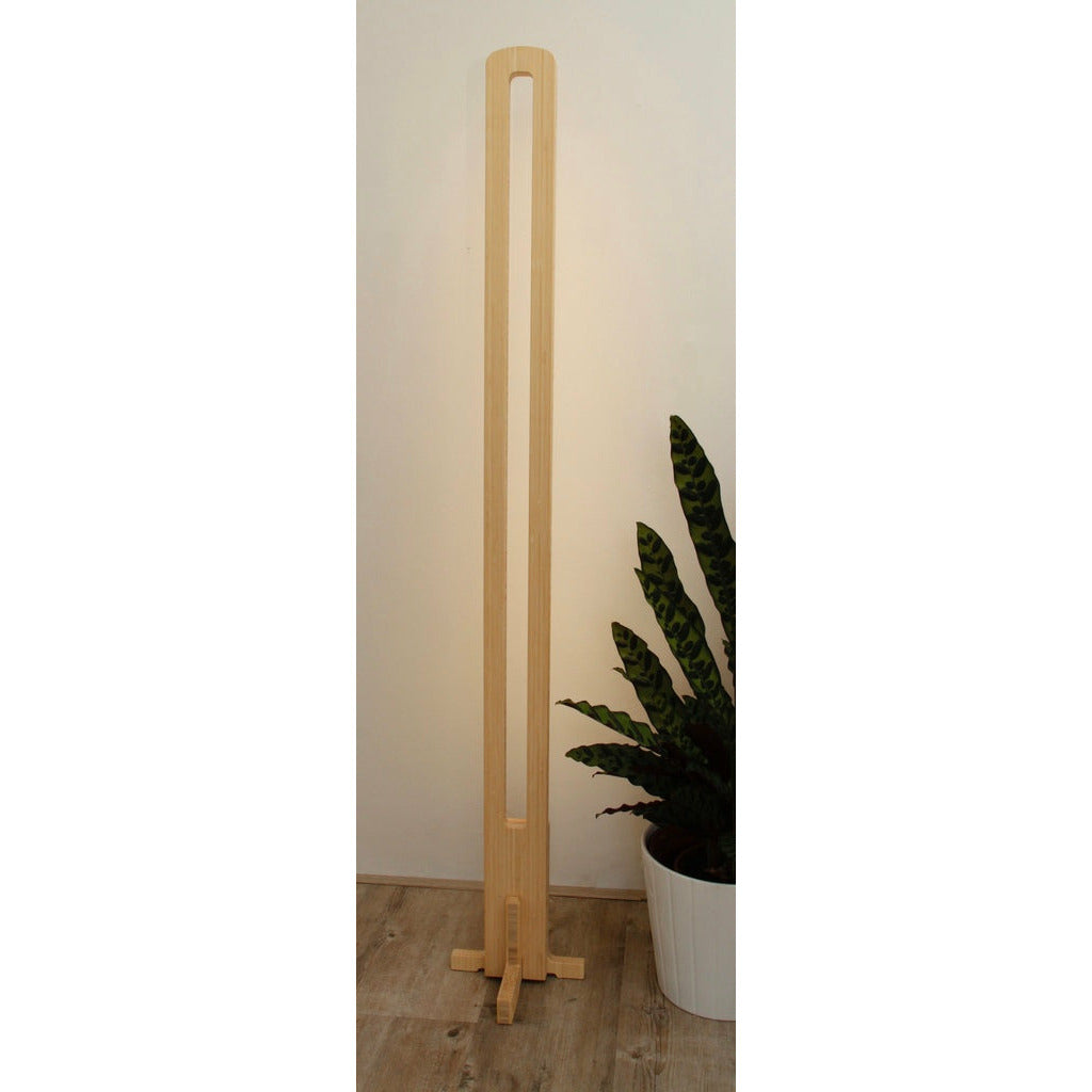 KuvaLight Parallel in Bamboo with a white light standing in front of a wall.